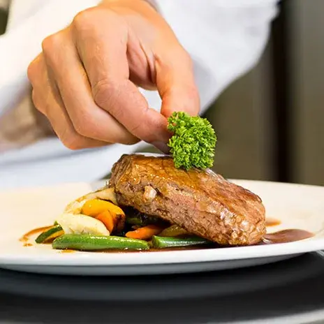 Capitol Ridge Chef Created Meals, chef garnishing a plate.